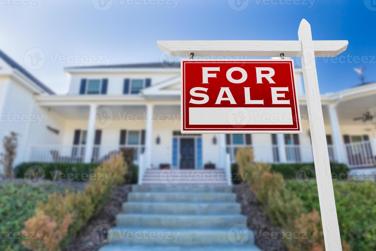 links gerichtetes Immobilienschild zum Verkauf vor dem Haus. foto