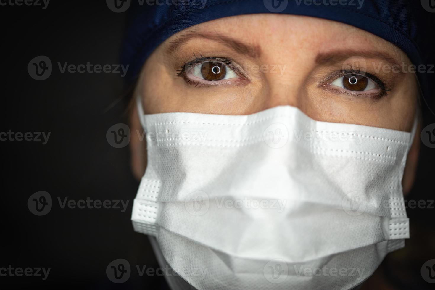 Ärztin oder Krankenschwester mit medizinischer Gesichtsmaske auf dunklem Hintergrund foto