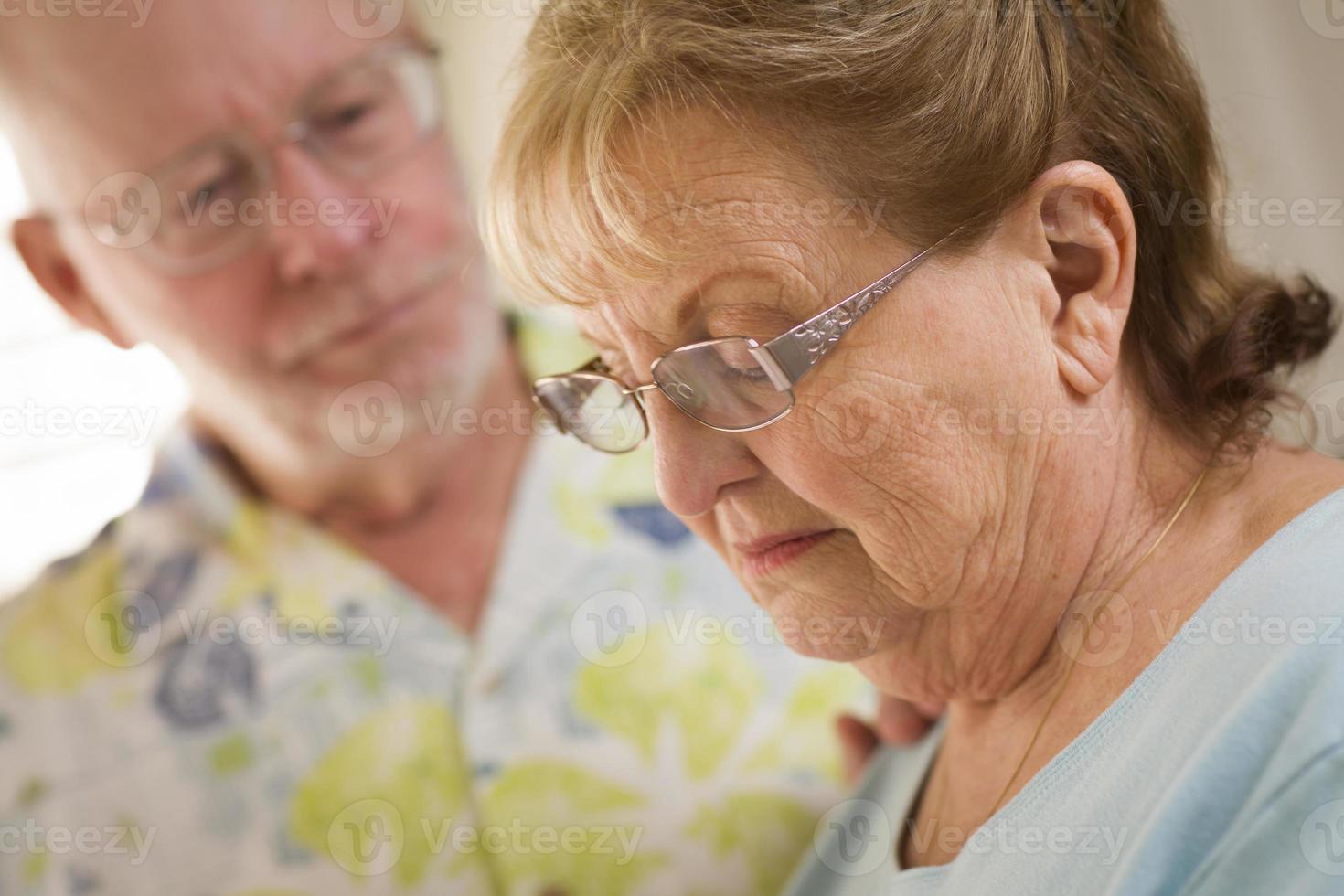 Senior erwachsener Mann tröstet traurige Senior erwachsene Frau foto