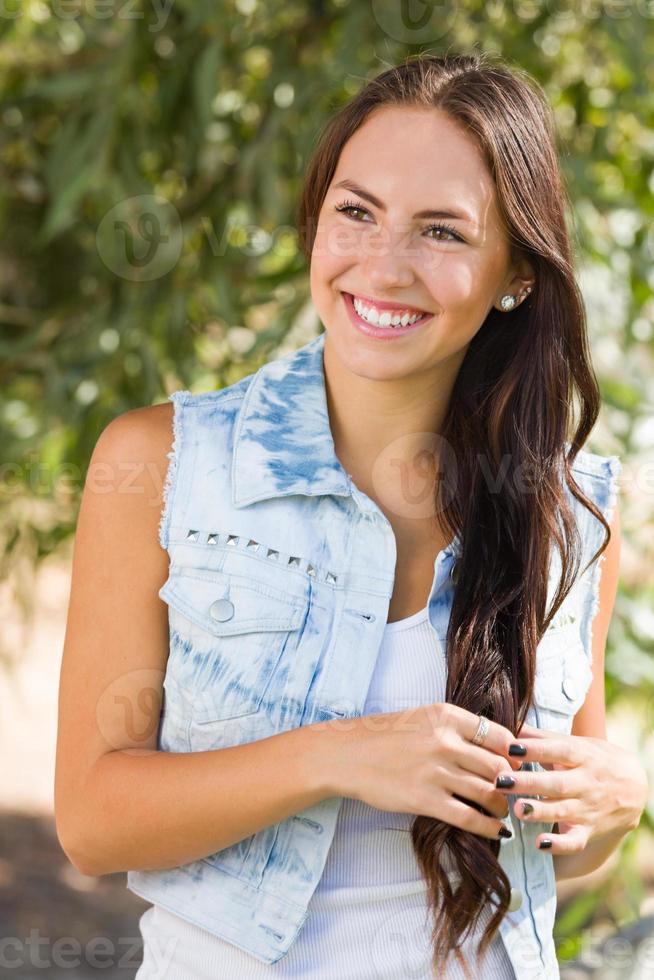 attraktives lächelndes Mischlingsmädchenporträt draußen foto