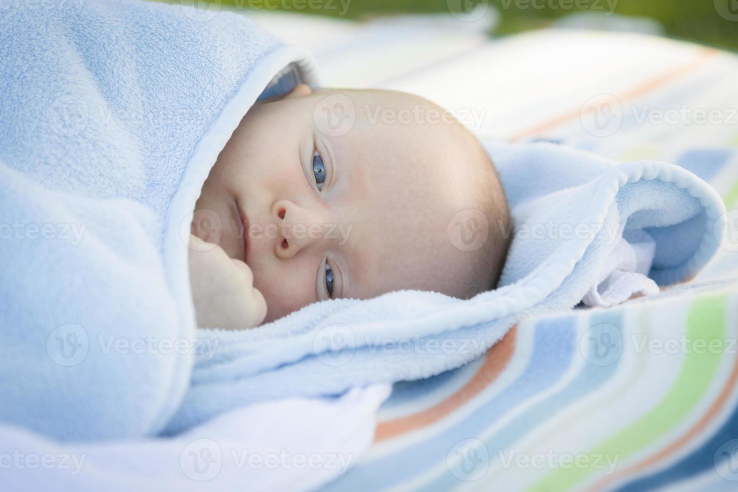kleiner Junge, der sich in seiner warmen Decke ausruht foto