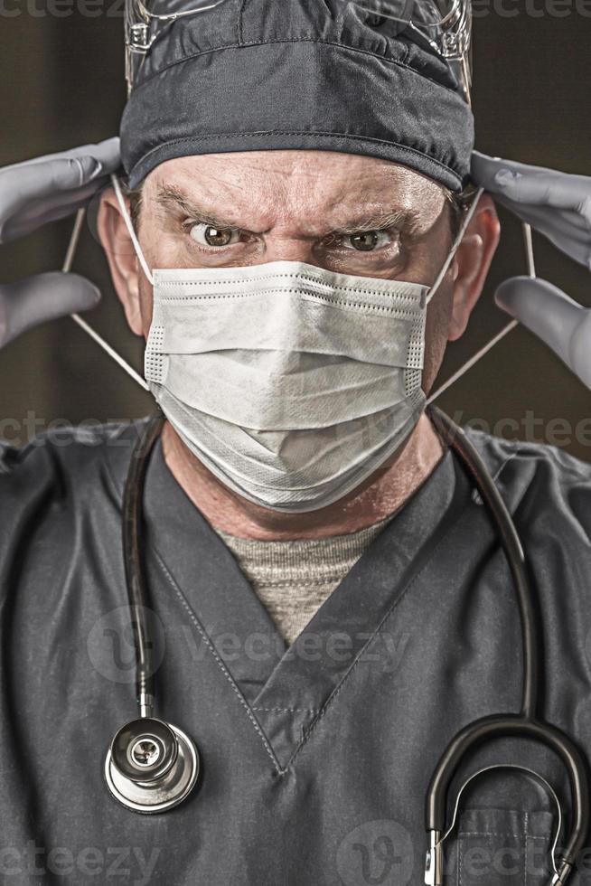 männlicher Arzt oder Krankenschwester mit Peelings, Schutzmaske und Schutzbrille foto