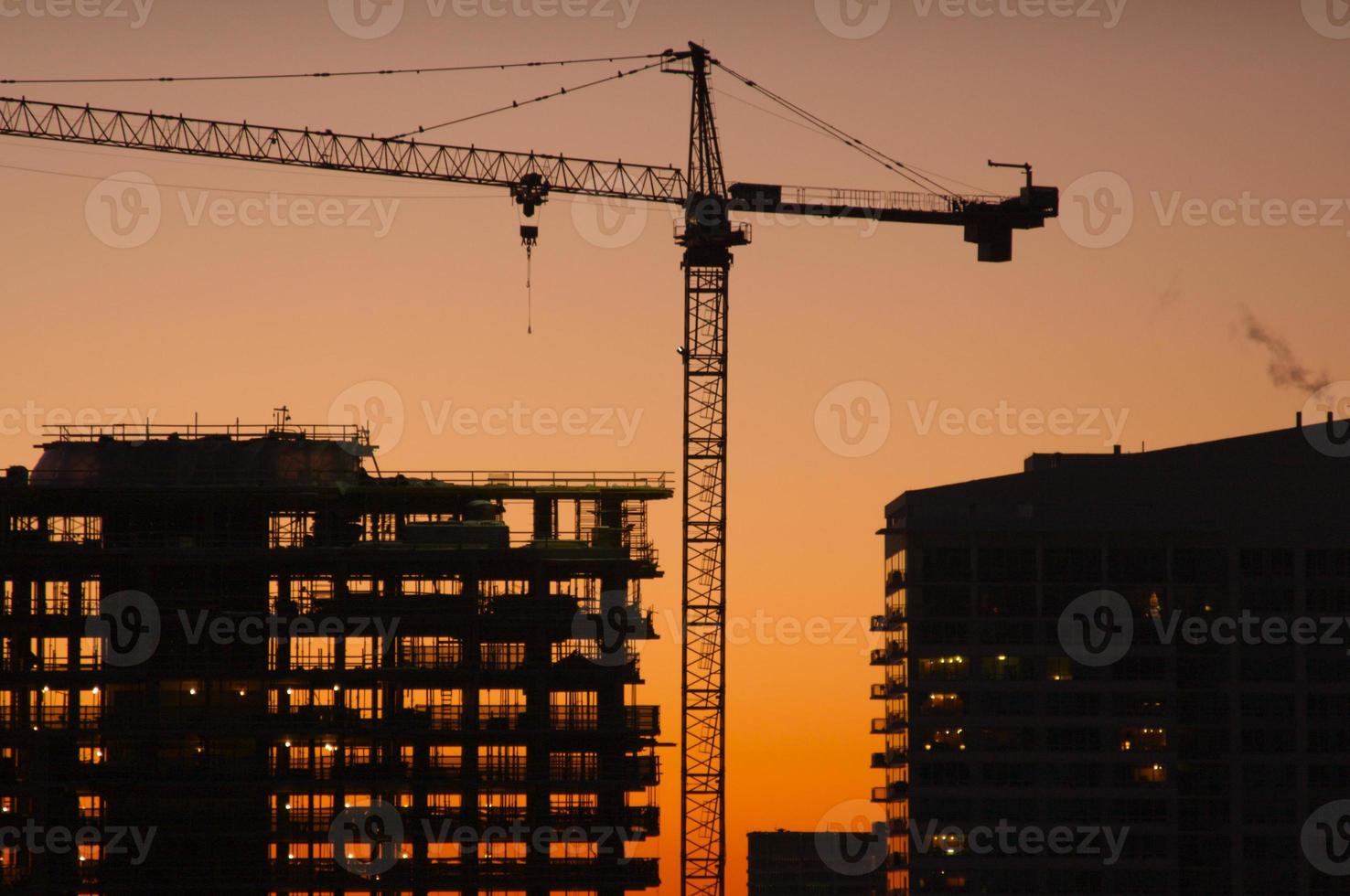 Silhouette von Kran und Gebäude foto