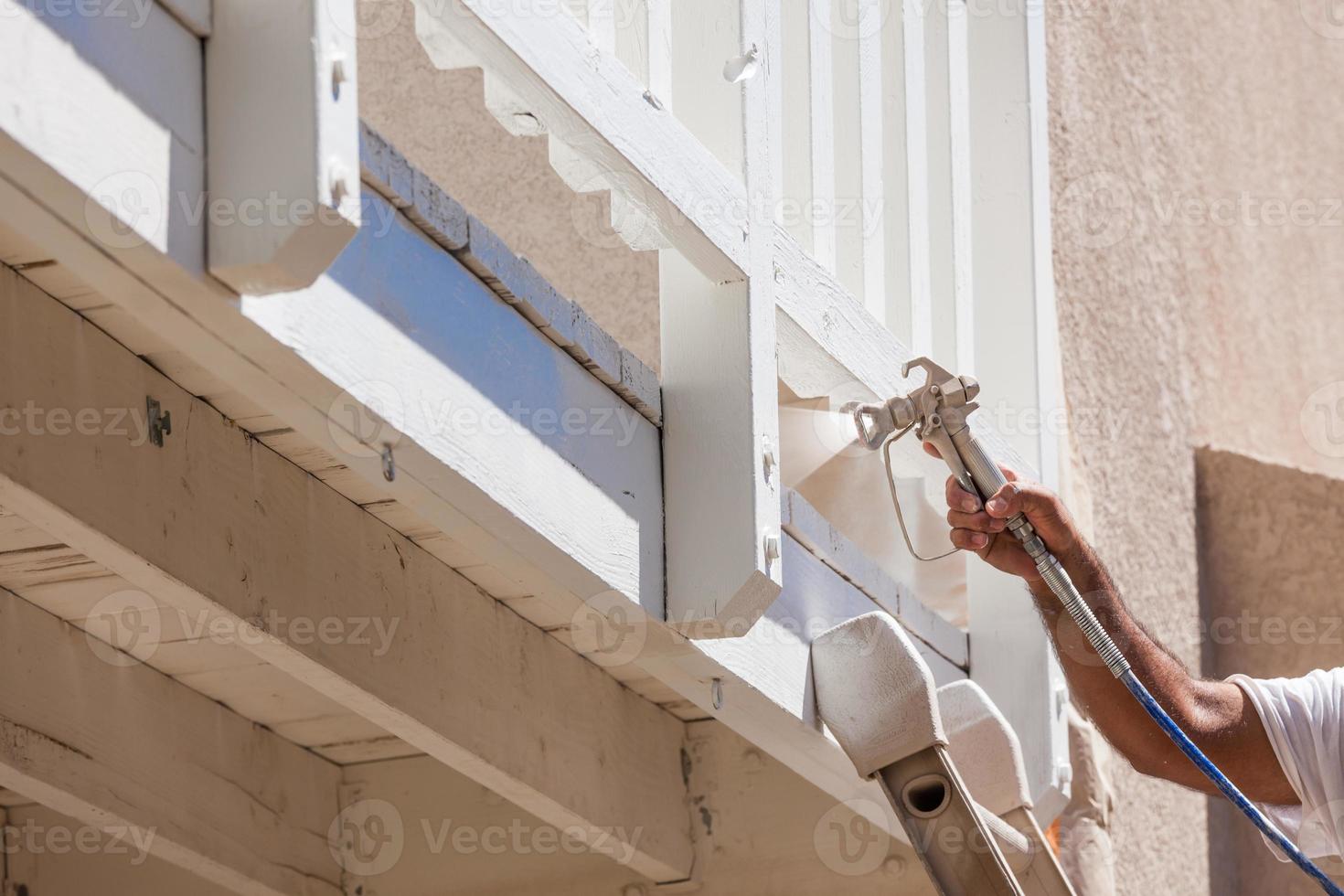 Anstreicher, der ein Deck eines Hauses sprüht foto