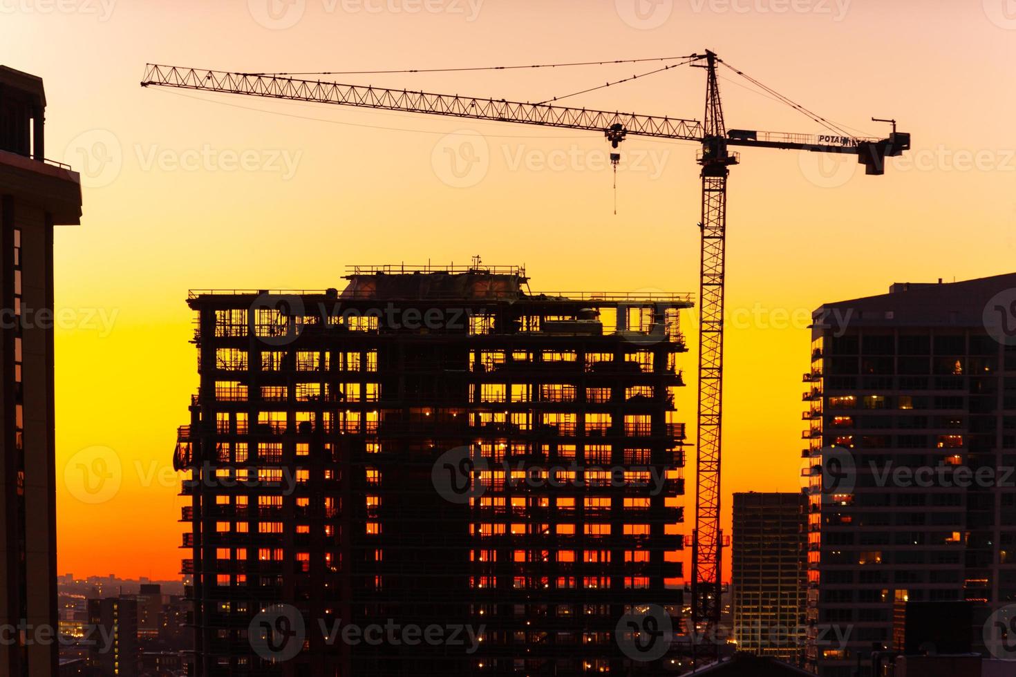 Silhouette von Kran und Gebäude im Bau in der Abenddämmerung. foto