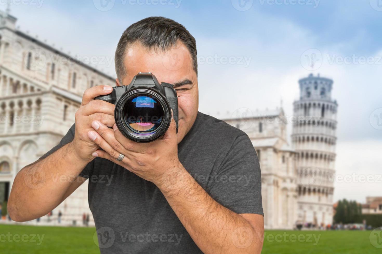 hispanischer männlicher fotograf mit kamera am schiefen turm von pisa foto