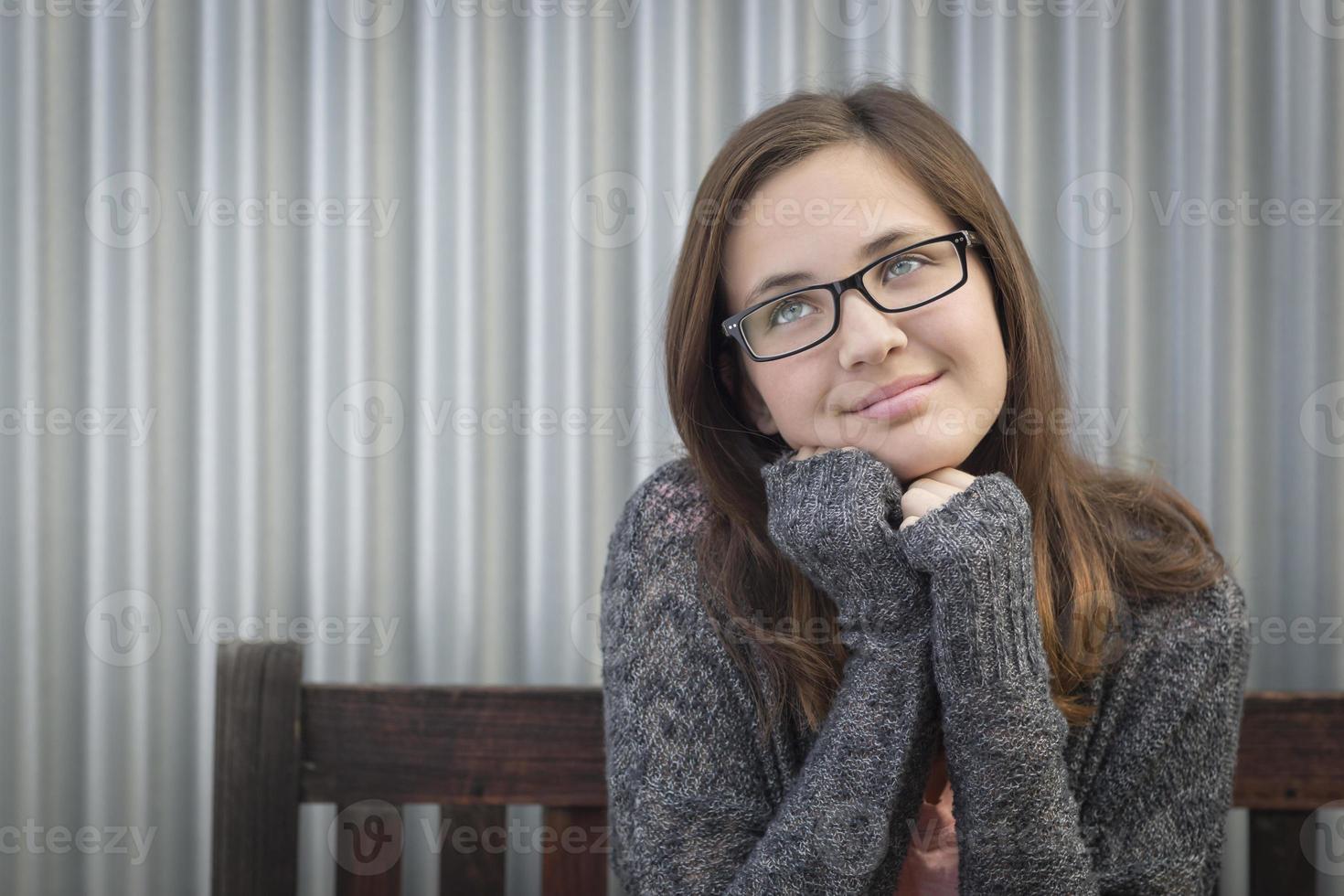 Tagträumendes junges Mädchen, das nach oben und zur Seite schaut foto