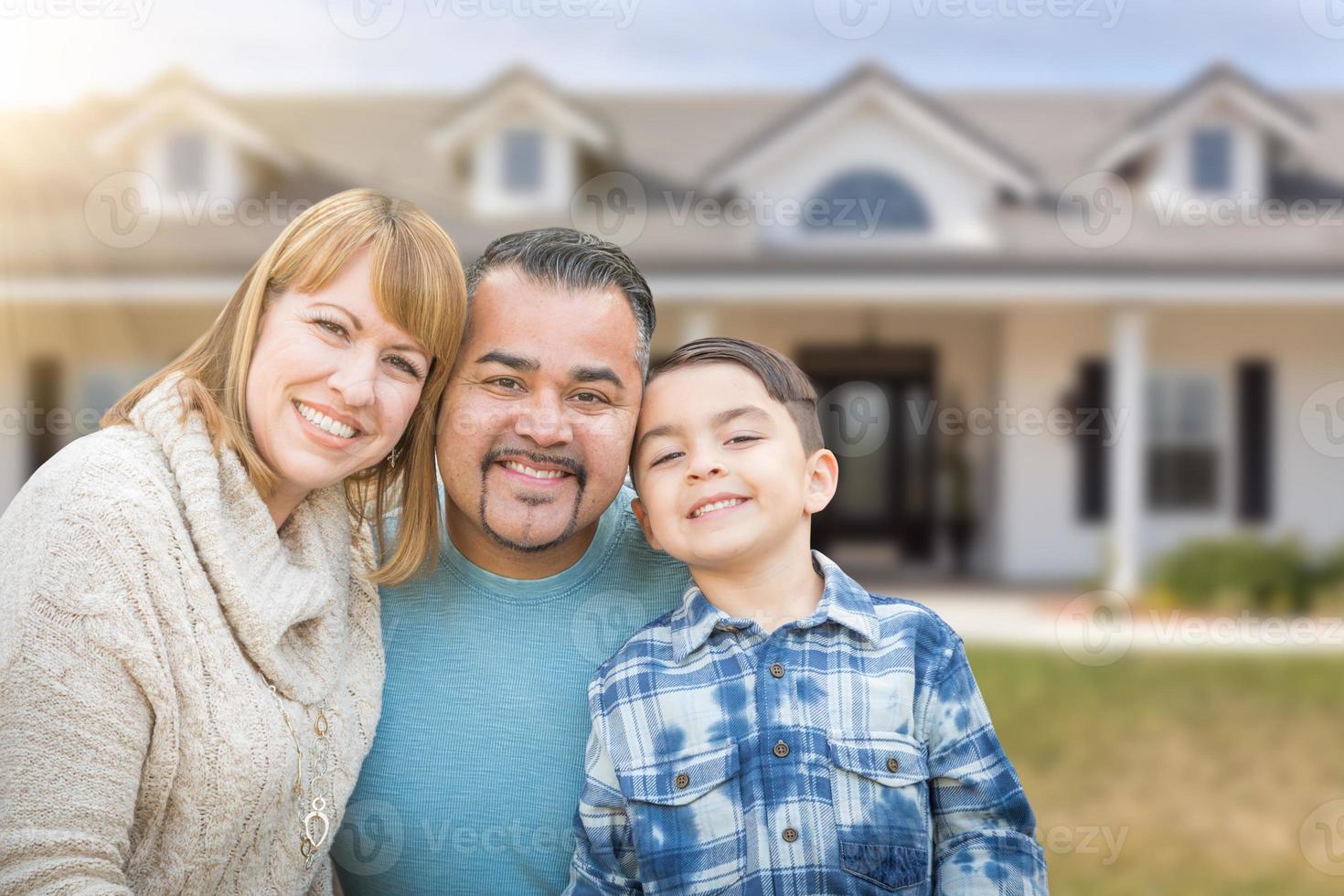 Mischlingsfamilie im Vorgarten eines schönen Hauses und Grundstücks. foto