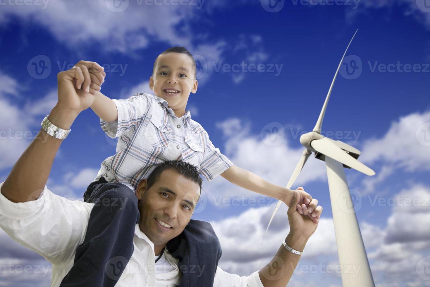 glücklicher hispanischer Vater und Sohn mit Windkraftanlage foto