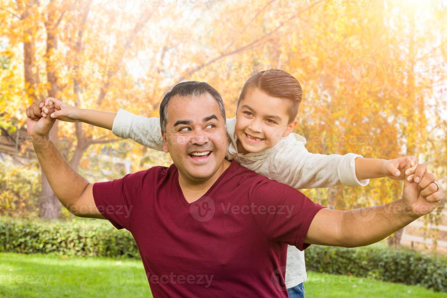 Hispanischer und kaukasischer Sohn und Vater gemischter Rassen, die sich im Park amüsieren foto