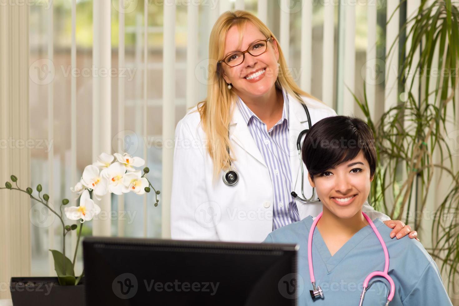 lächelnde Ärztinnen oder Krankenschwestern gemischter Abstammung in Büroumgebung foto