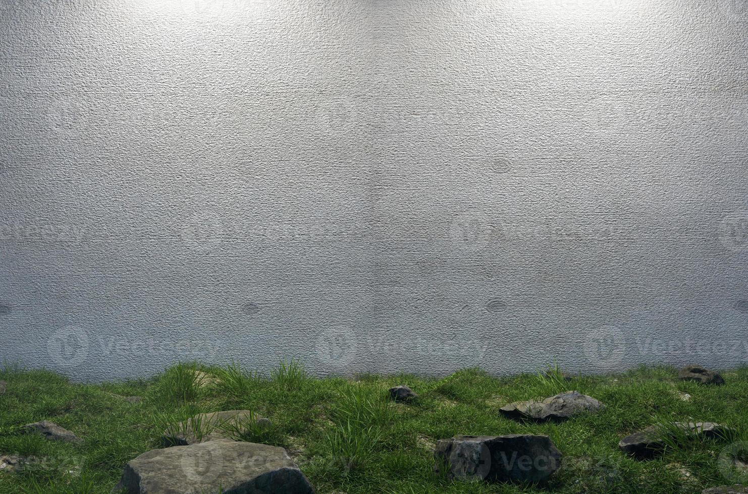 mysteriöse leere zementwand, umgeben von großen felsen und gras auf dem feld. foto