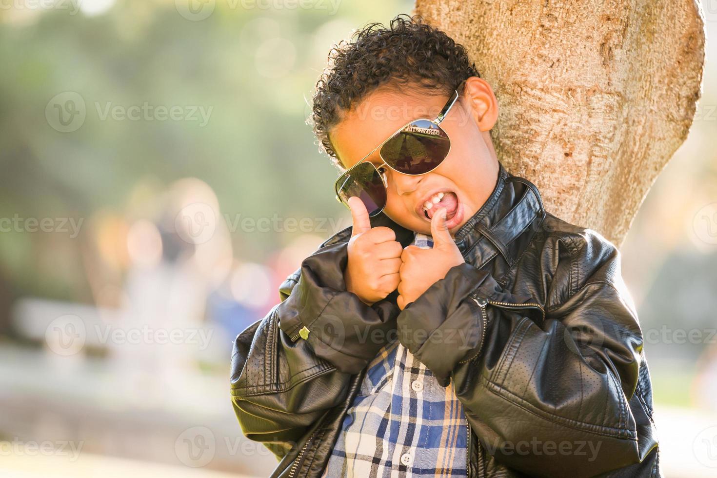 afrikanisch-amerikanischer und mexikanischer Junge mit Sonnenbrille und Lederjacke foto