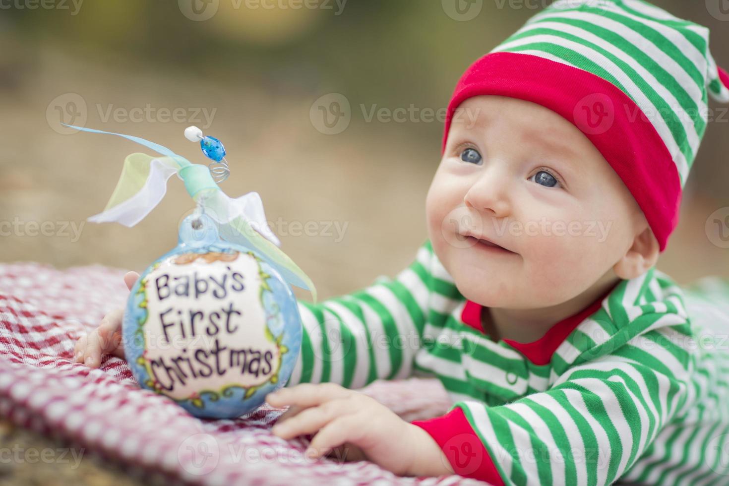 Säuglingsbaby auf Decke mit erstem Weihnachtsschmuck des Babys foto