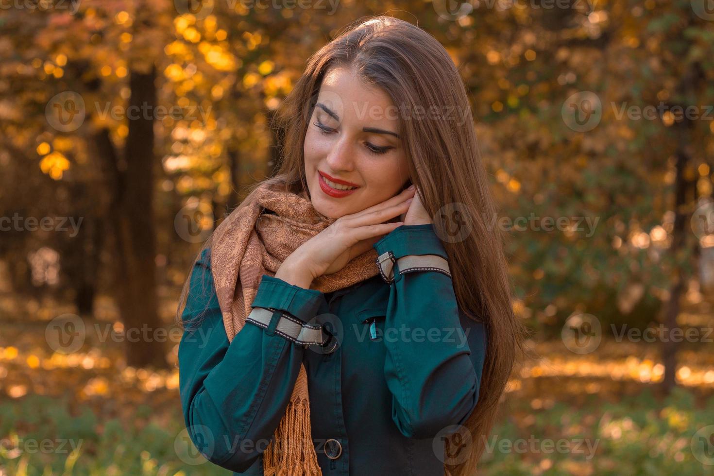 süßes mädchen steht im park und hält sich die hände unter die haare schließe deine augen foto