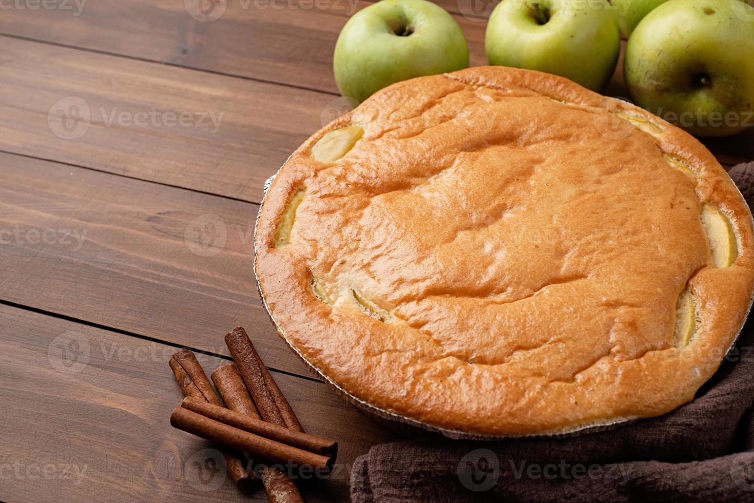 Apfelkuchen Charlotte auf Holztisch mit frischem Apfel und Zimt foto