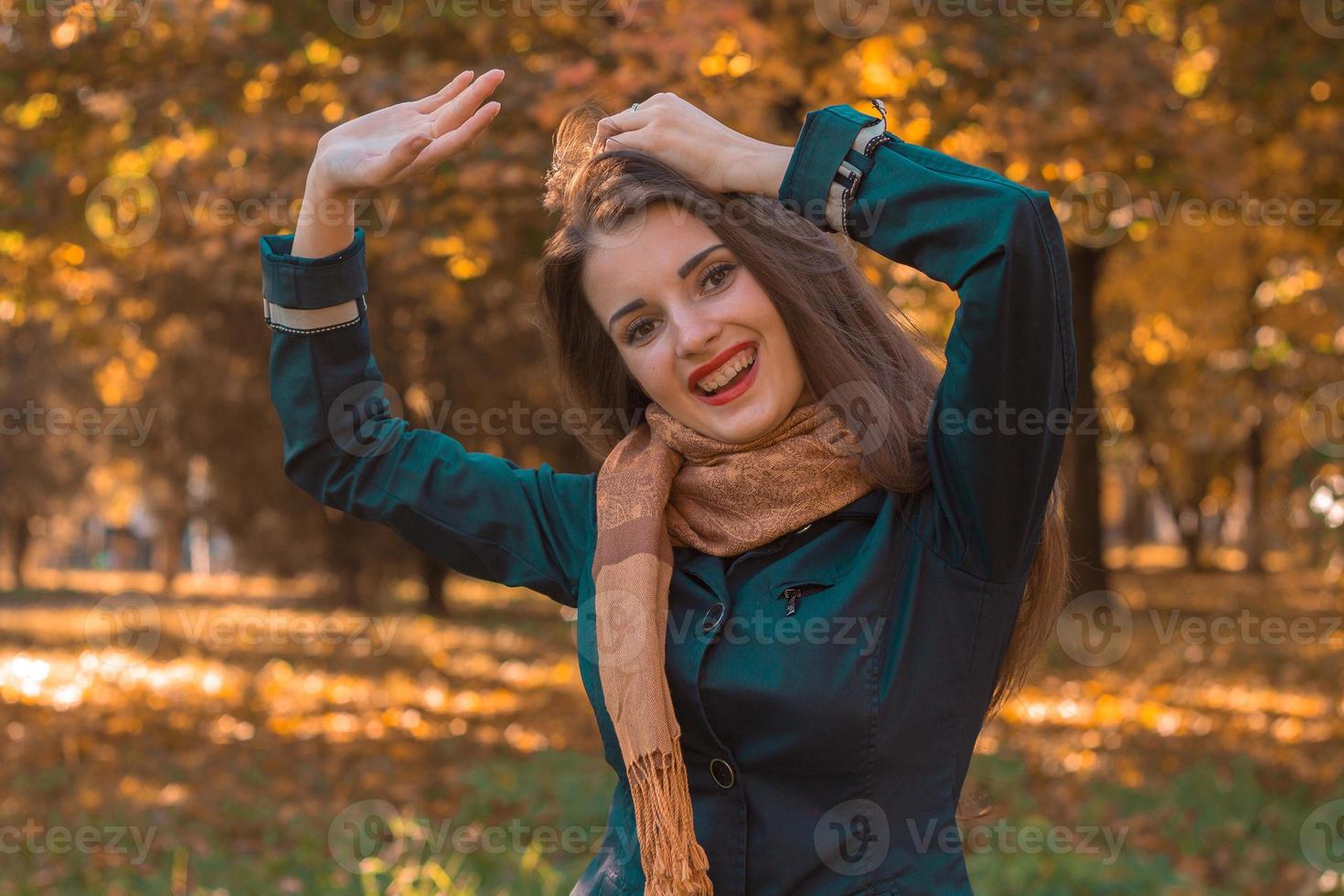 süßes lustiges mädchen steht im park und hob die hände hoch foto