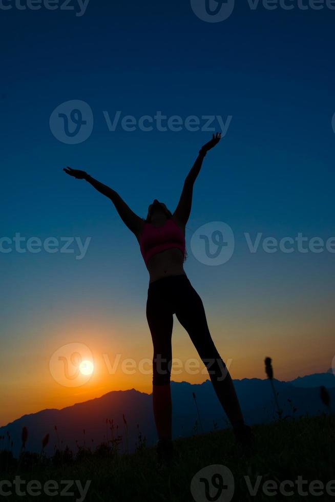 Silhouette der Frau bei Sonnenuntergang in den Bergen foto