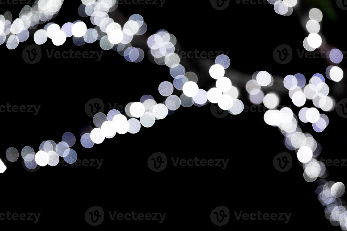 abstraktes glitzerndes bokeh, das auf schwarzem hintergrund defokussiert ist. Viele runde Lichter im Hintergrund foto