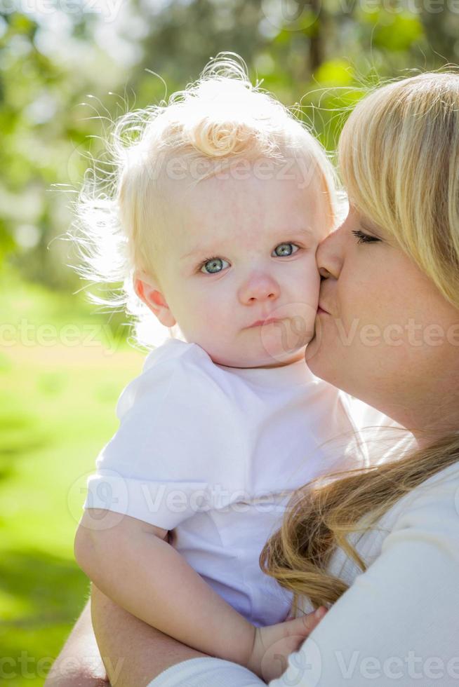 junge Mutter, die ihren entzückenden kleinen Jungen hält foto