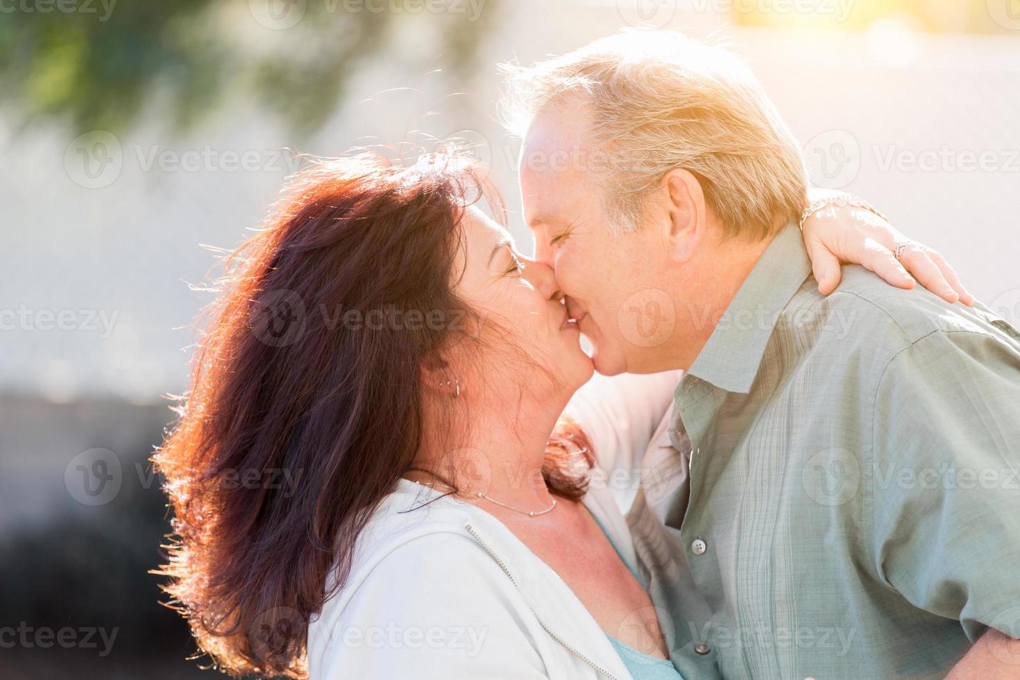 Paar mittleren Alters genießt einen romantischen langsamen Tanz und küsst sich draußen foto