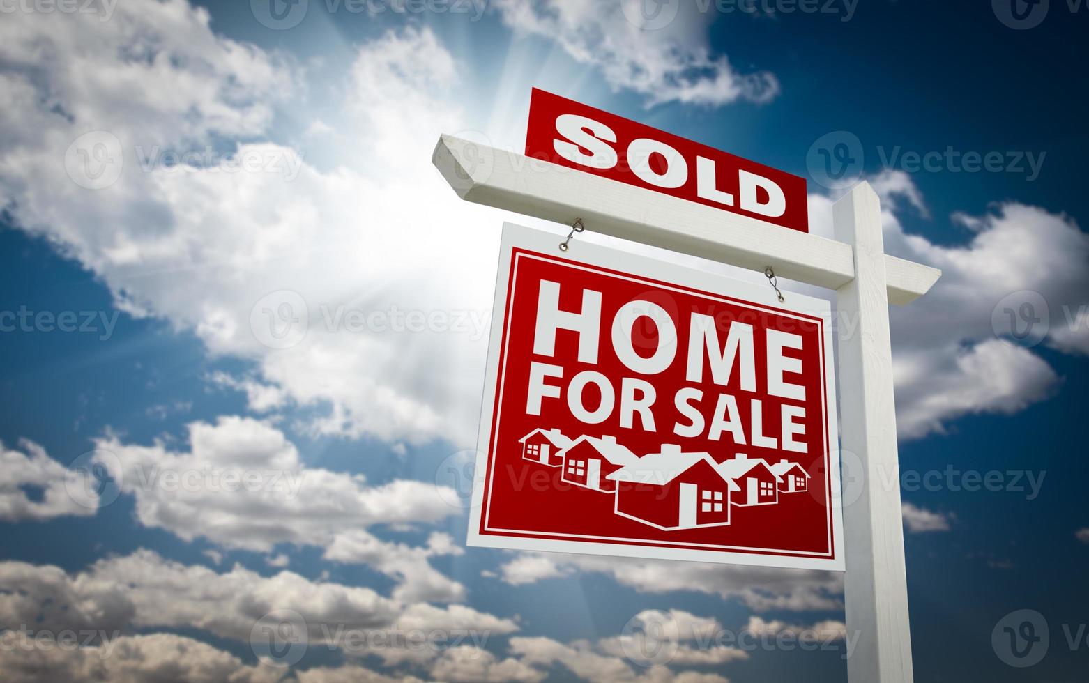 rot verkauftes Haus zum Verkauf Immobilienschild über Wolken und Himmel foto