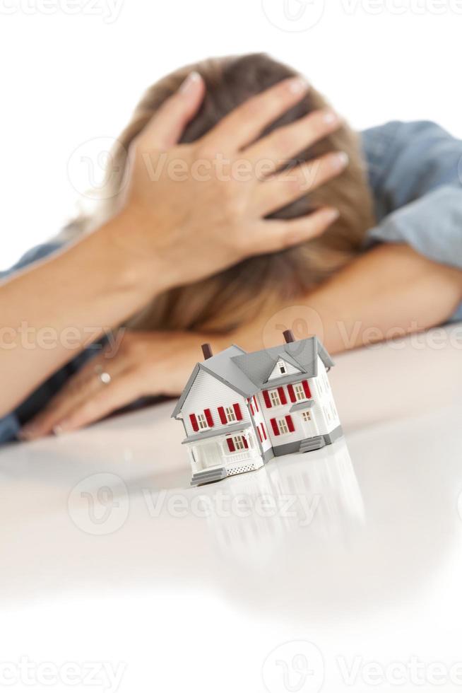 Frau mit Kopf in der Hand hinter Musterhaus foto