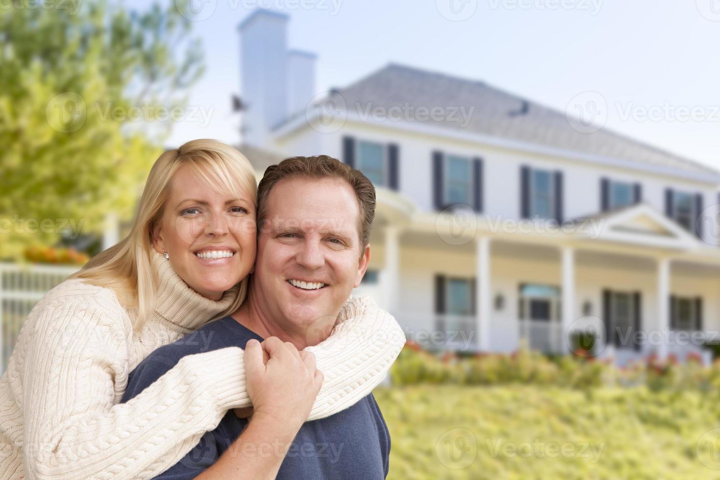 glückliches Paar, das sich vor dem Haus umarmt foto