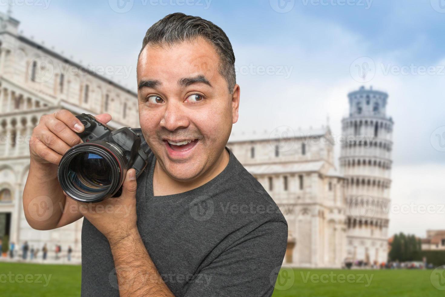 hispanischer männlicher fotograf mit kamera am schiefen turm von pisa foto