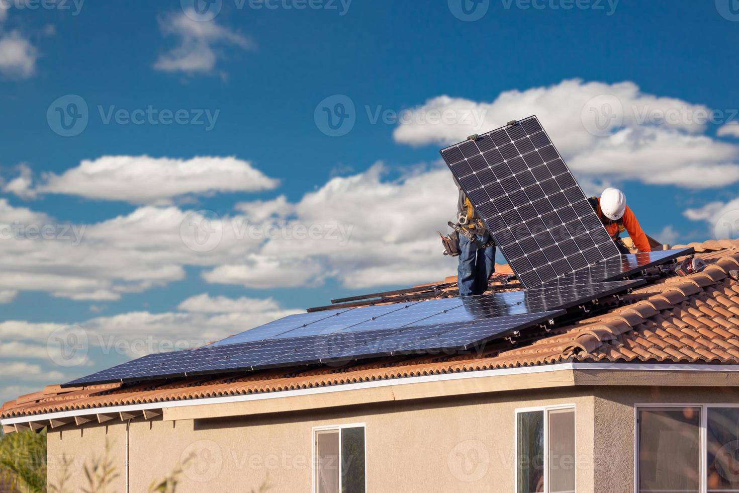 Arbeiter installieren Sonnenkollektoren auf dem Hausdach foto