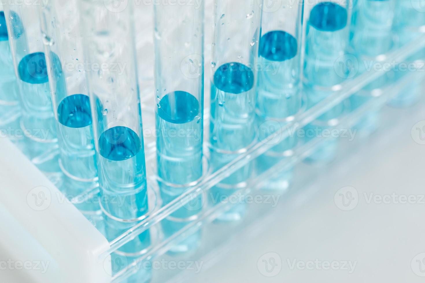Zusammenfassung der wissenschaftlichen Reagenzgläser mit blauer Chemikalie im Gestell foto