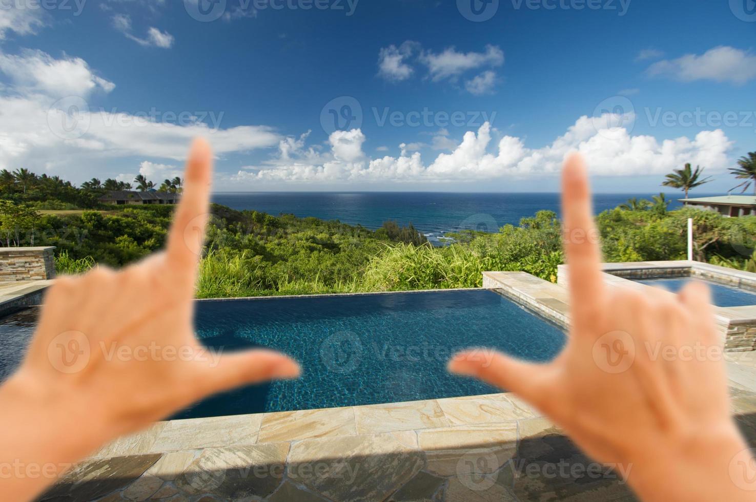 Hände, die den Pool und die Terrasse mit Meerblick einrahmen foto