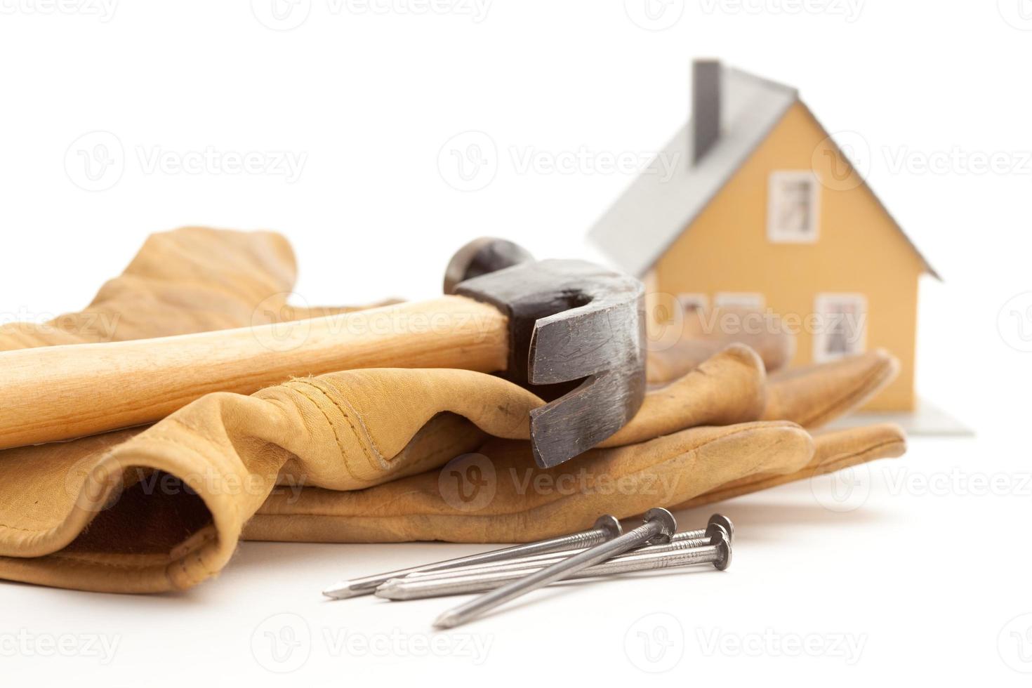 Hammer, Handschuhe, Nägel und Haus foto