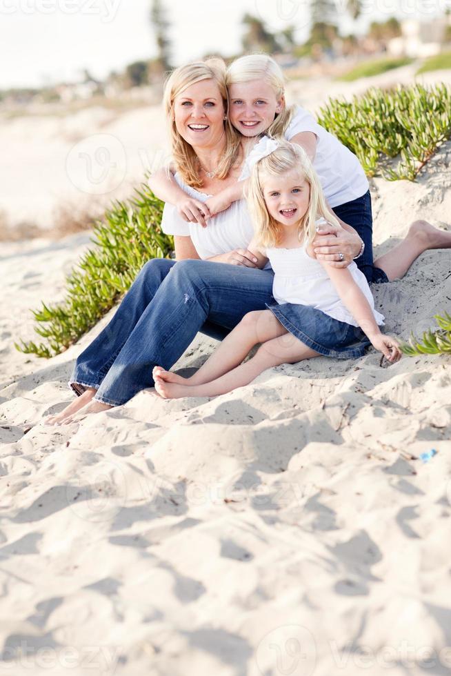hübsche Mutter und ihre süßen Töchter am Strand foto