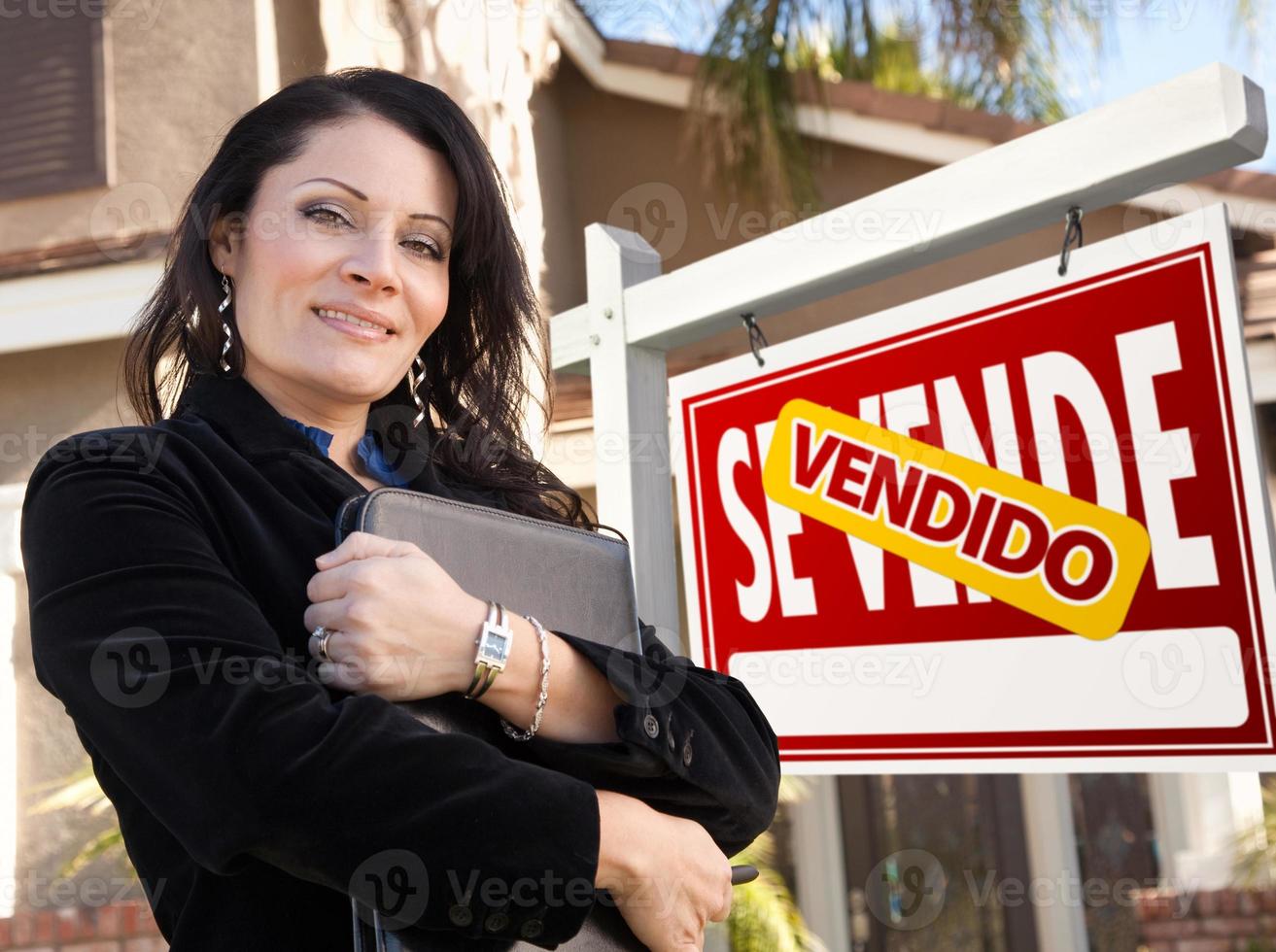 weiblicher hispanischer immobilienmakler, vendido se vende zeichen und haus foto