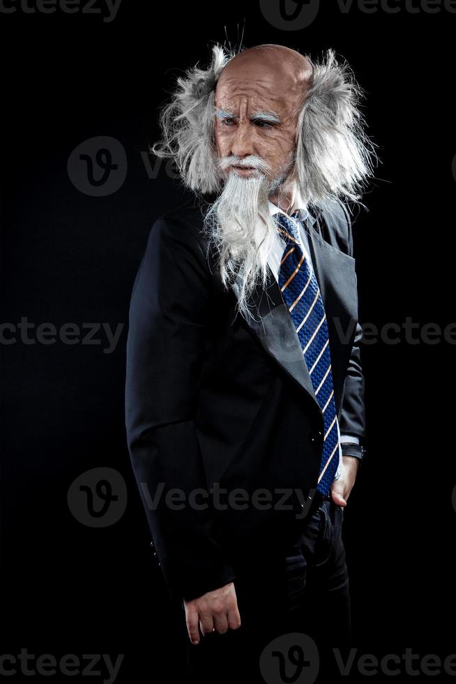 hübscher alter mann im klassischen schwarzen anzug, der wegschaut foto