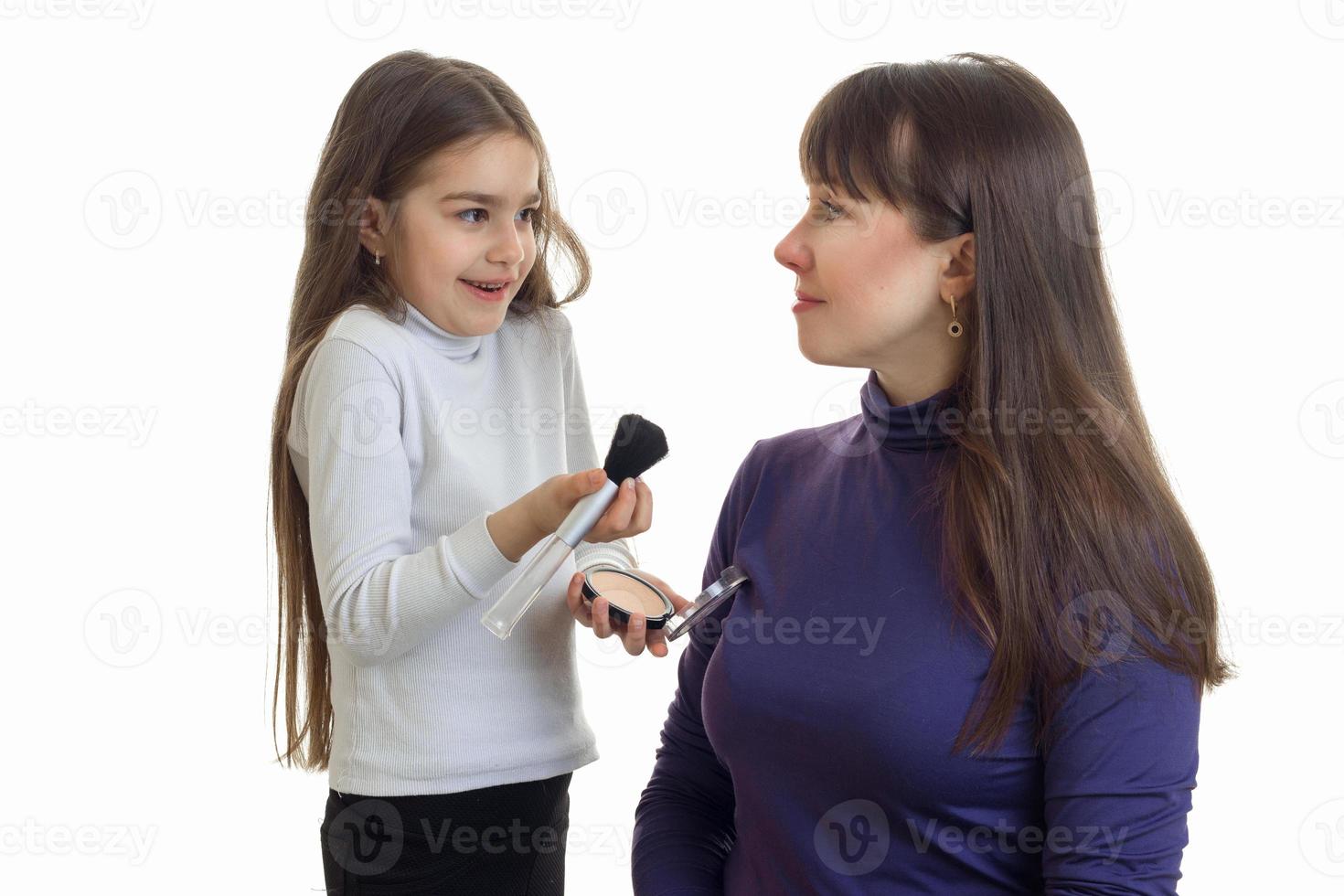 kleines lächelndes Mädchen malt ihre Mutter erröten ist auf einem weißen Hintergrund isoliert foto