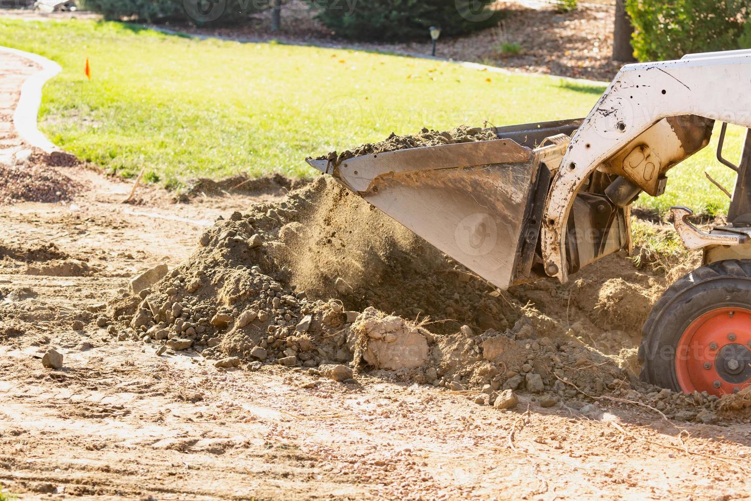 kleiner Bulldozer, der im Hof für die Poolinstallation gräbt foto