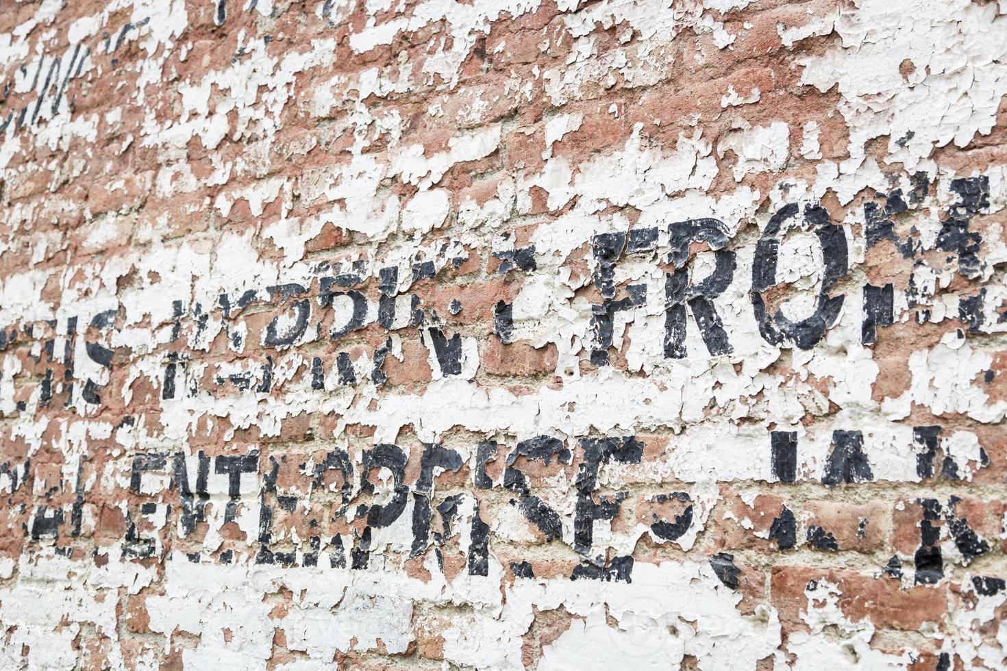 alte verwitterte Backsteinmauer mit Werbung foto