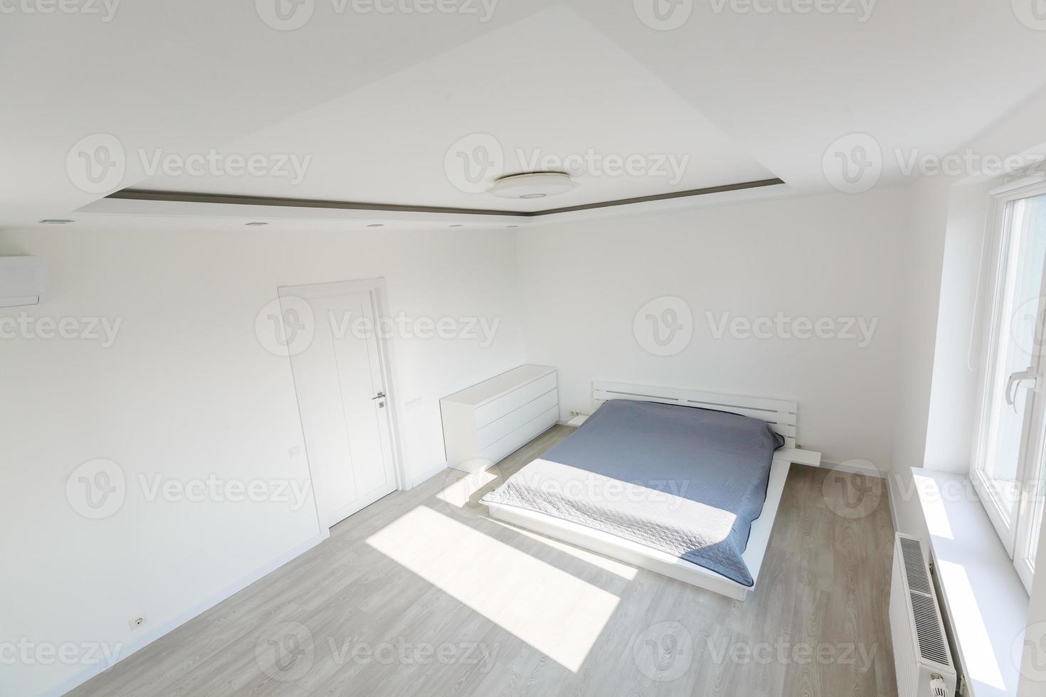 weißer schlafzimmerinnenraum mit großem bett foto