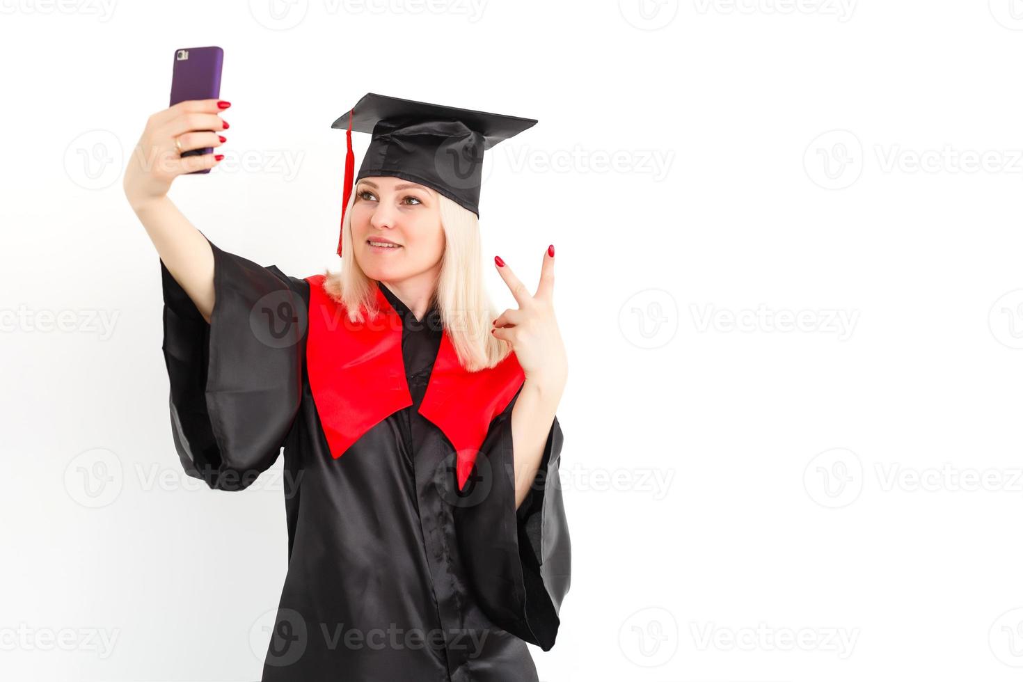 Aufgeregte, glückliche Studentin steht im Mantel, lächelt und schaut in die Kamera foto