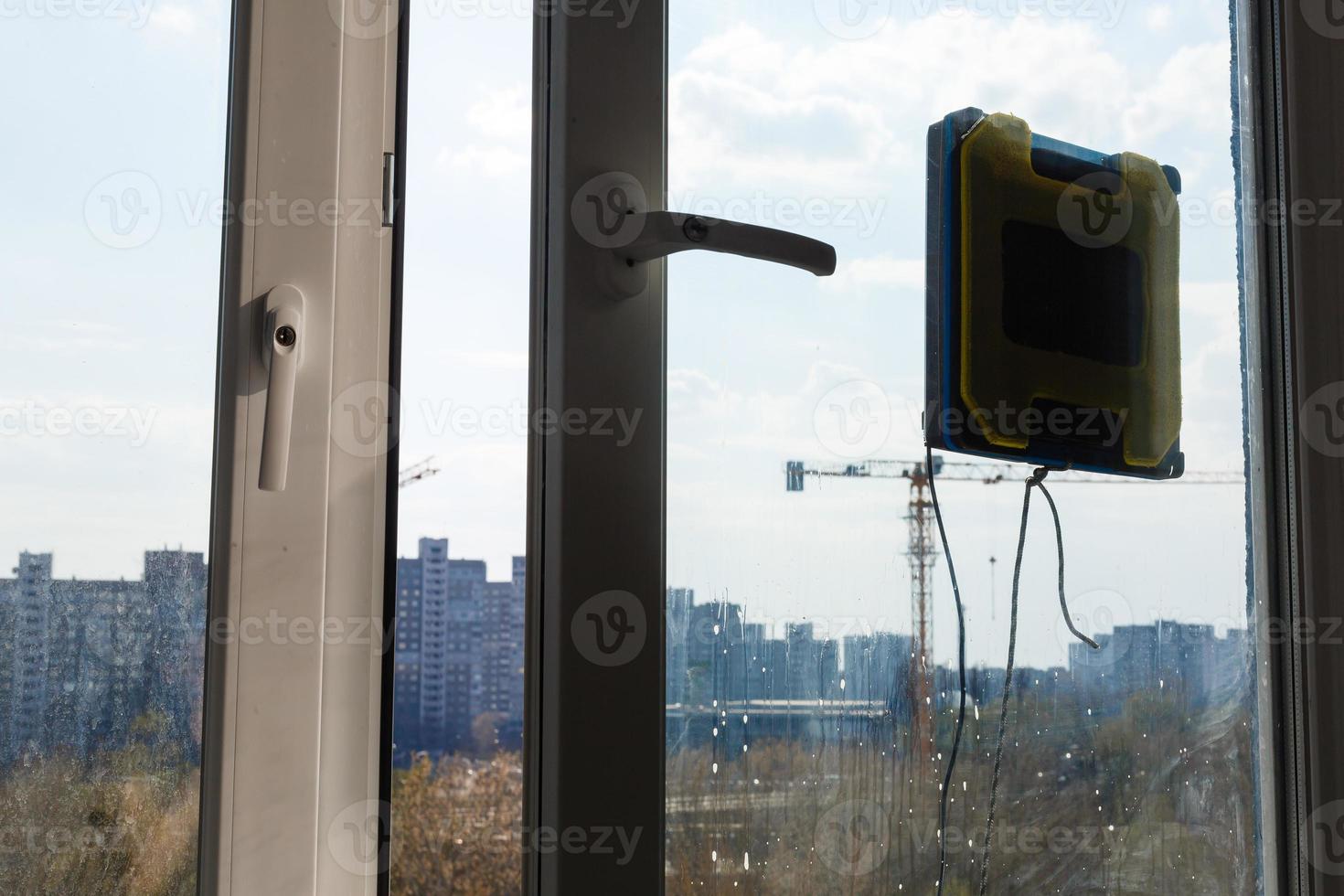 Roboter-Fensterputzer arbeiten an schmutzigen Fenstern. Reinigung des Hauses mit intelligenten Geräten. automatische Saugroboter zum Fensterputzen, ein Assistent für zu Hause. foto