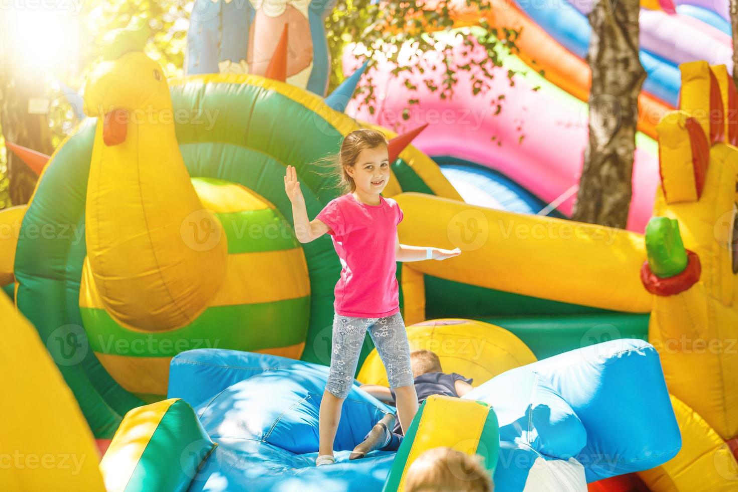 Fröhliches kleines Mädchen, das auf einem Trampolin spielt foto