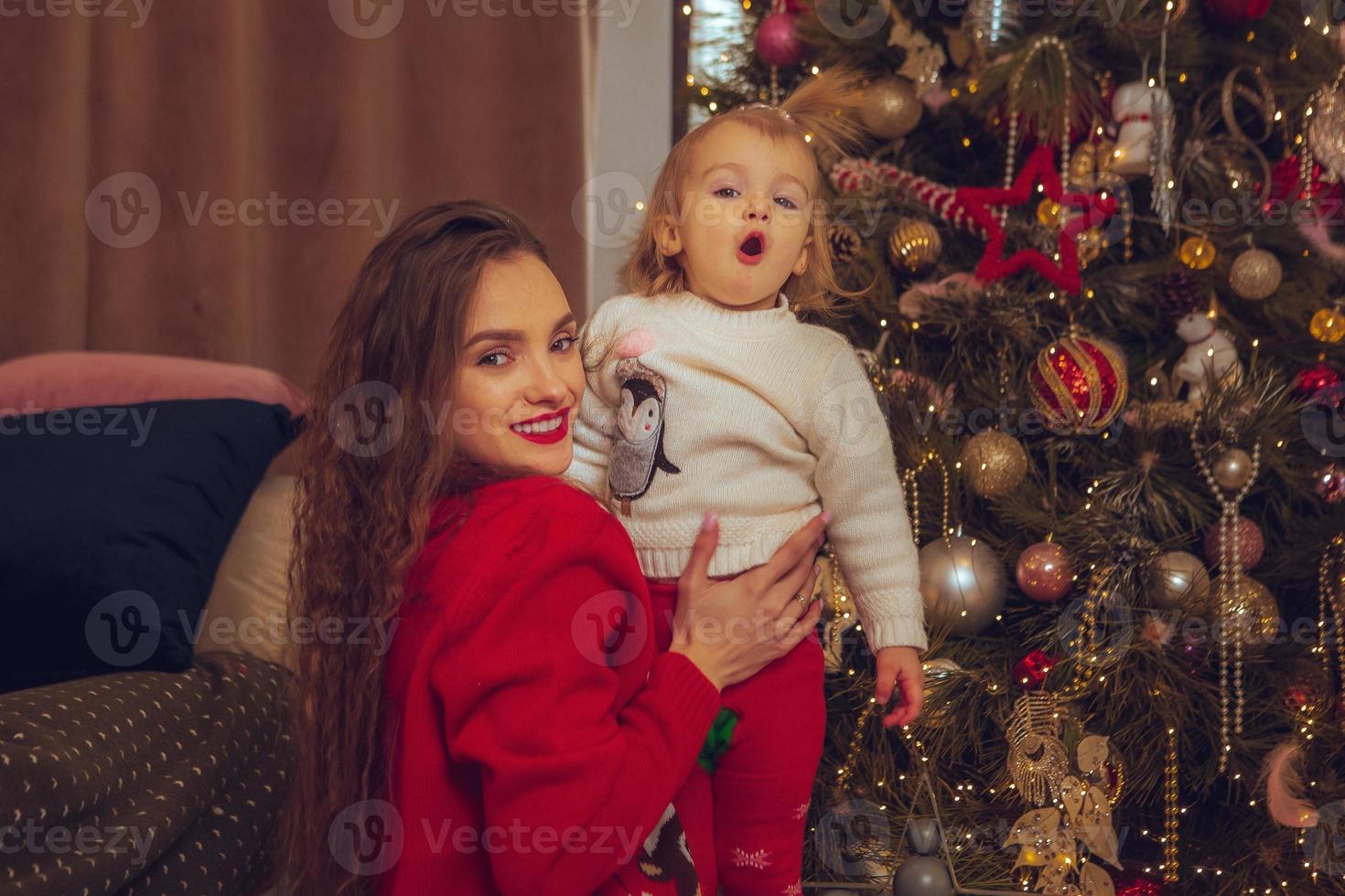 horizontales foto der süßen mutter und ihrer kleinen tochter am weihnachtsbaum