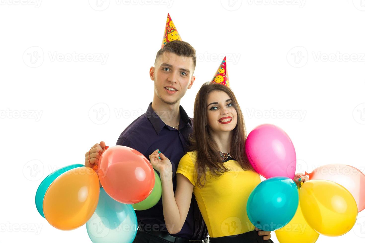 Fröhliches schönes Paar feiert Geburtstag, lacht und hält viele Bälle foto