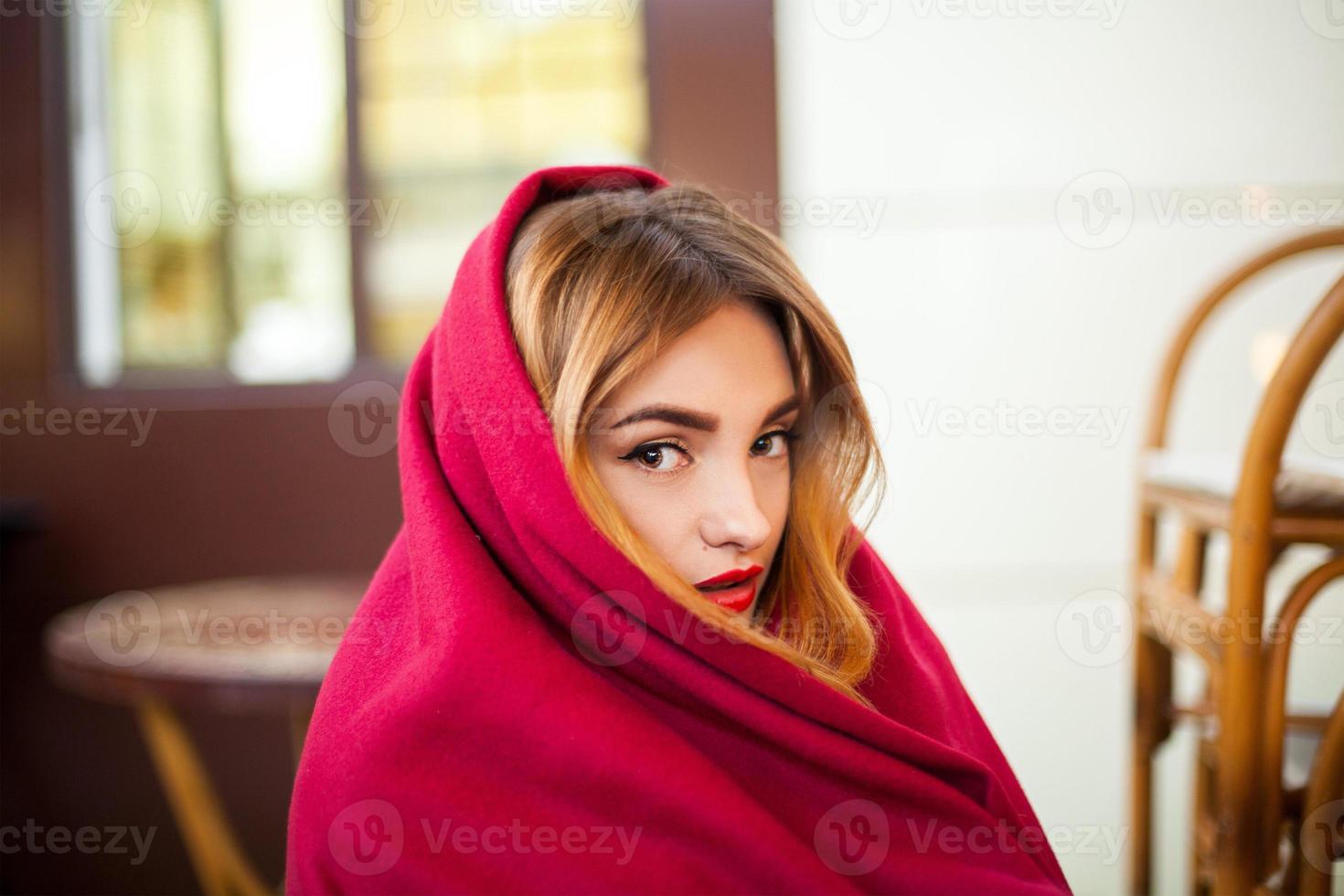 Mädchen mit roten Lippen in eine Decke gehüllt foto
