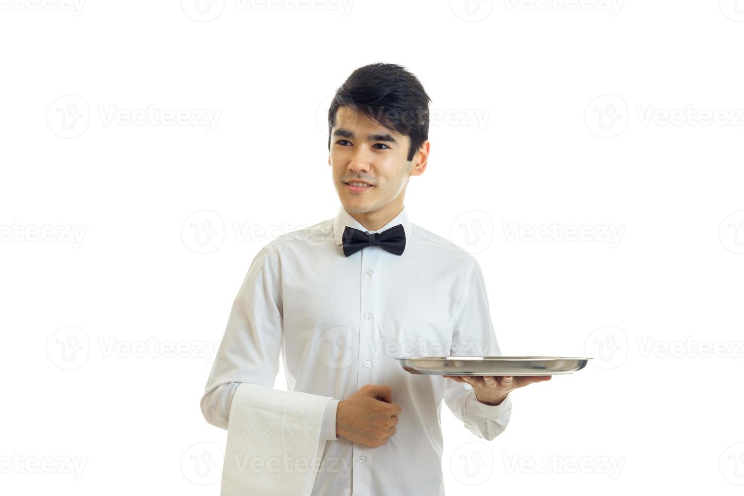 junges lächelndes kellnerhemd, das ein tablett mit geschirr hält foto