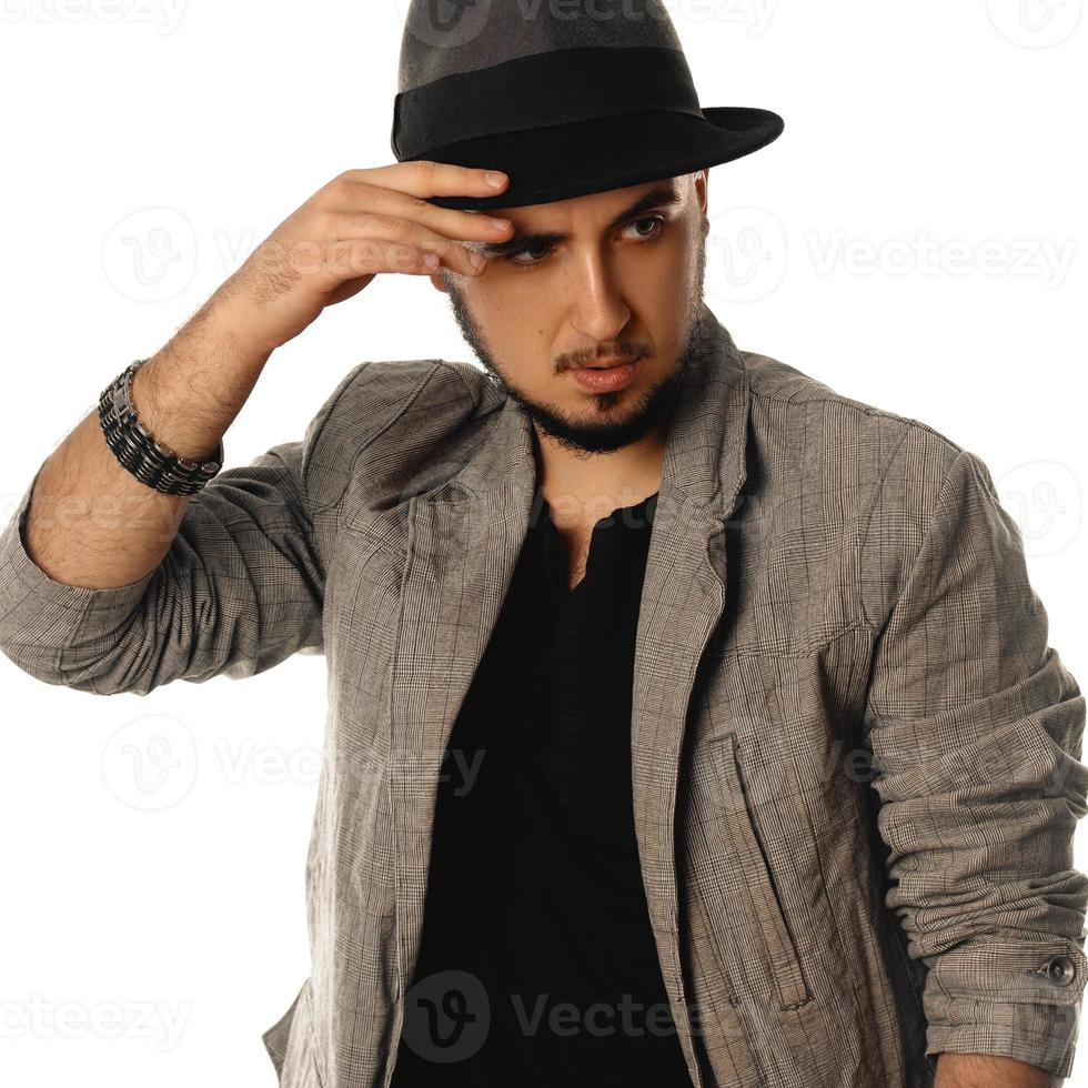 Quadratisches Porträt eines jungen Glamour-Mannes mit Hut und Jacke, der wegschaut foto