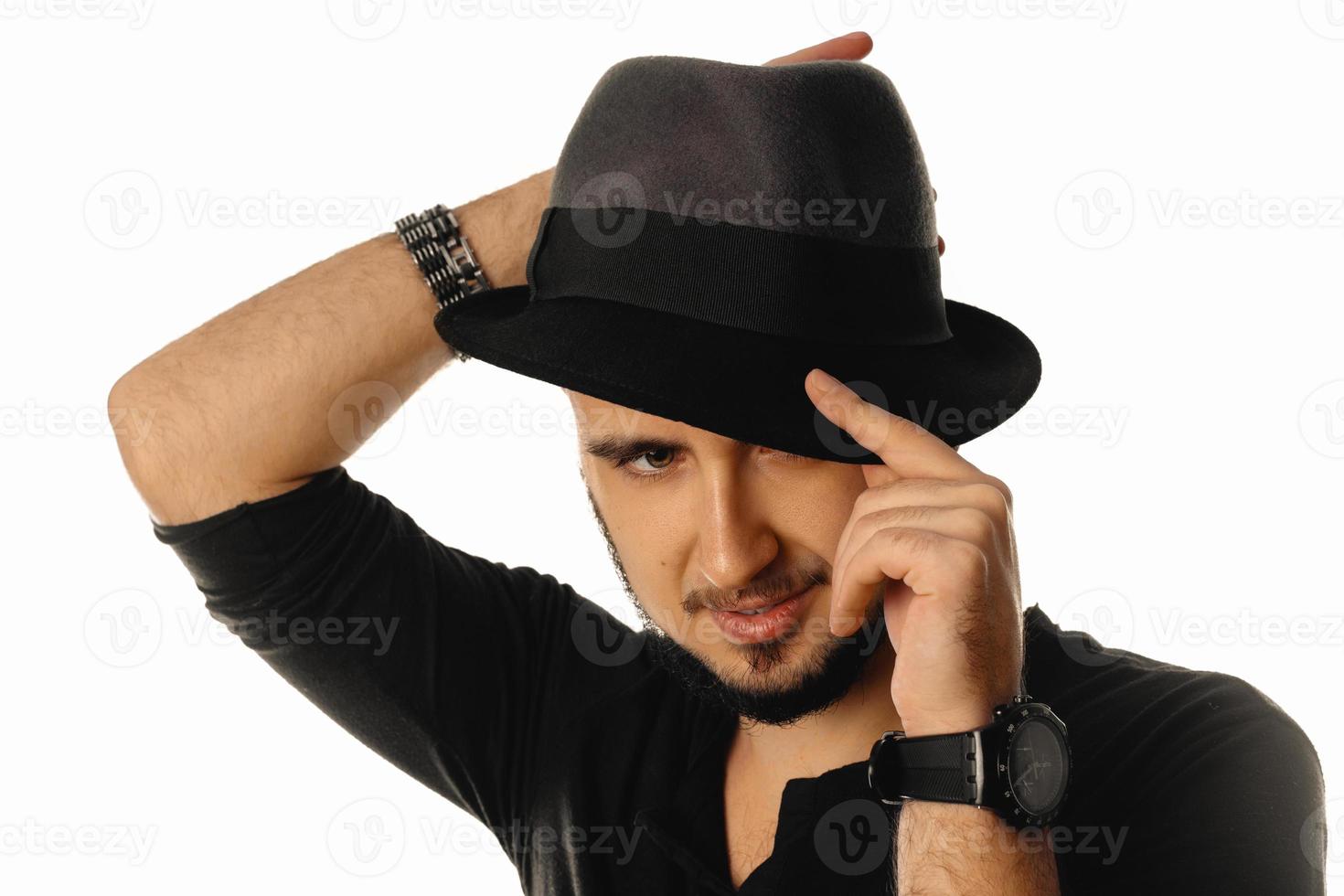 schöner Macho-Mann mit Hut, der isoliert auf weißem Hintergrund wegschaut foto