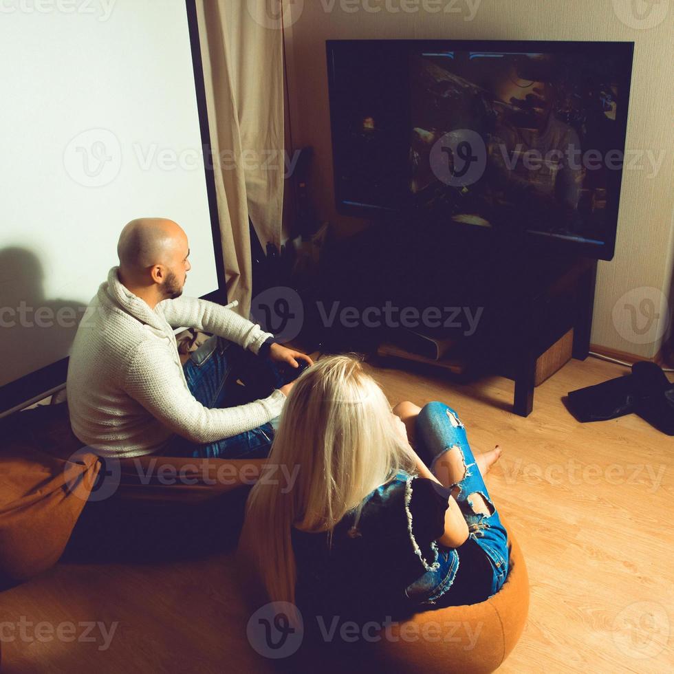 Fotoquadrat von Paaren, die Spaß haben und Computerspiele im Fernsehen spielen foto